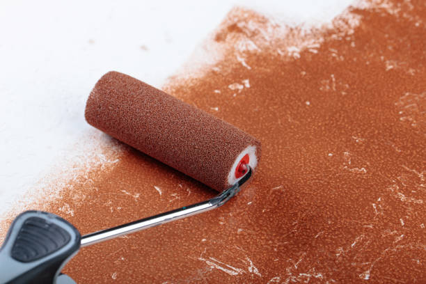 istock Painting roller  surface copper paint  inside in apartment close up. 981771058
