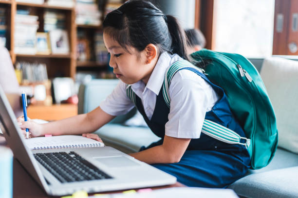 istock Chinese girl doing homework and using laptop 981775122