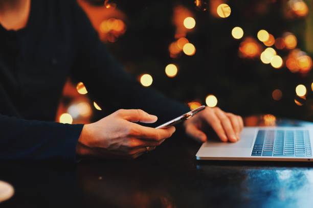 istock Cropped Hands Of Man Using Smart Phone By Laptop At Table 981776142