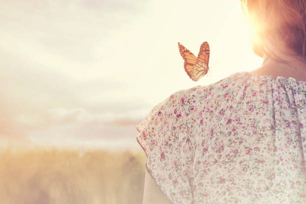 moment privilégié de rencontre entre un papillon et une fille au milieu de la nature - women nature inspiration ideas photos et images de collection