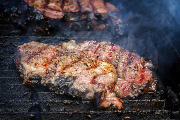 istock Juicy steak cooks over hot coals in the smoke 981777954