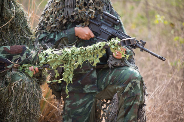 istock Army Soldiers With Rifle Kneeling In Forest 981782412