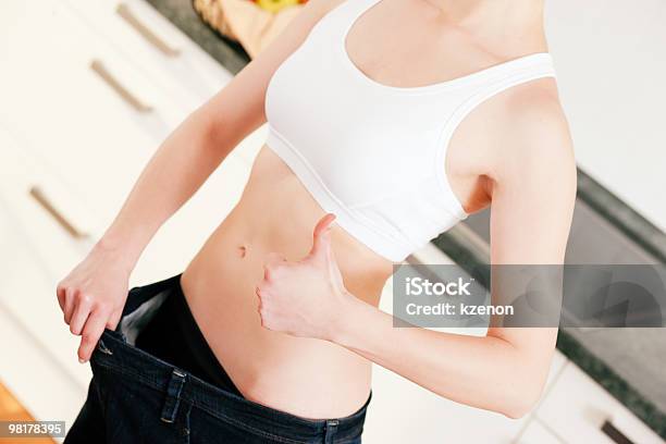 Régimen Mujer Con Grandes Pantalones Foto de stock y más banco de imágenes de Abdomen humano - Abdomen humano, Adulto, Alegre