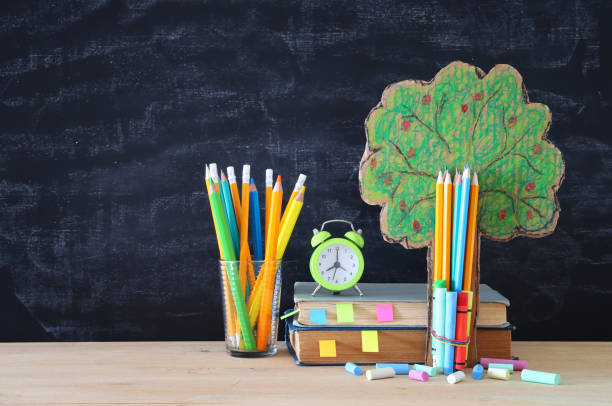 istock Back to school concept. tree of knowledge and pencils in front of classroom blackboard. 981784356