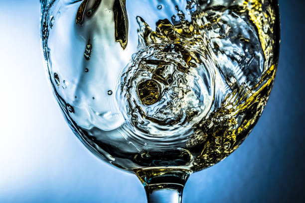 weiß wein splash auf grauem hintergrund, strom von weißwein in ein glas gießen. hell-siehe foto. - wine decanter elegance pouring stock-fotos und bilder