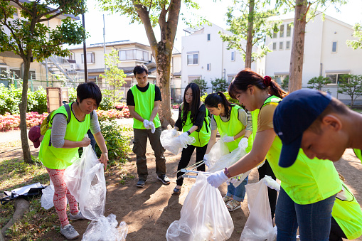 A group of volunteers are cleaning a public park in Tokyo.