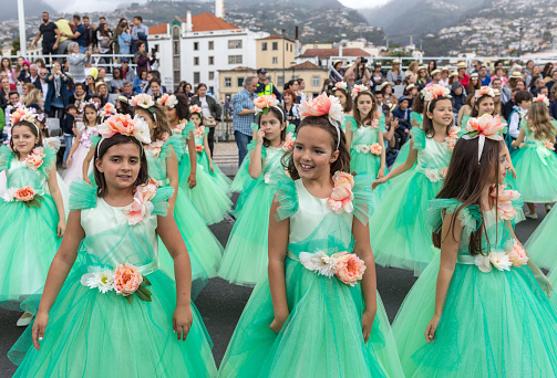 Funchal; Madeira; Portugal - April 22; 2018: A group of girls in colorful costumes are dancing at Madeira Flower Festival Parade in Funchal on the Island of Madeira. Portugal.