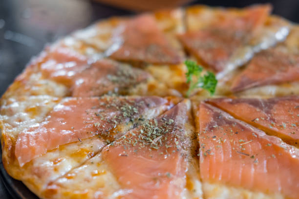 istock Close up of Salmon Pizza on the table. 981806864
