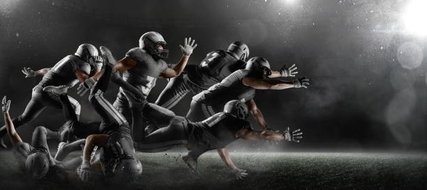 American football players in dark sport stadium American football players fights for the ball and fall in dark sport stadium with fog. Sport team are dressed in black uniform american football field photos stock pictures, royalty-free photos & images