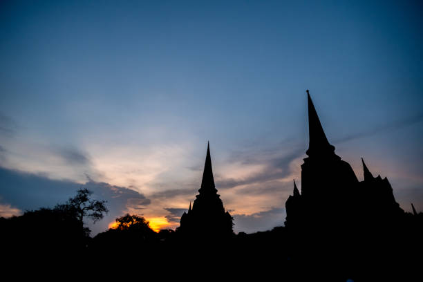 silhouette de wat phra sri sanphet, le plus sacré temple sur le site de l’ancien palais royal, dans l’ancienne capitale de la thaïlande d’ayutthaya. contre le ciel coucher de soleil coloré - sanphet palace photos et images de collection