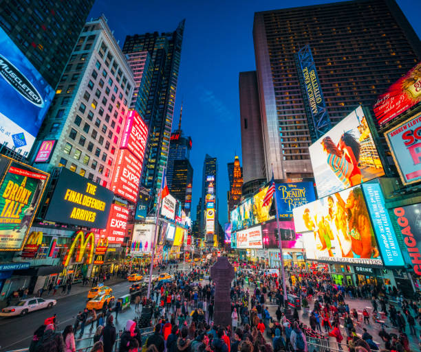 Times Square in New York City at dusk Times Square covered with illuminated billboards during the 'blue hour' period at dusk, with tourists on the streets. commercial sign stock pictures, royalty-free photos & images