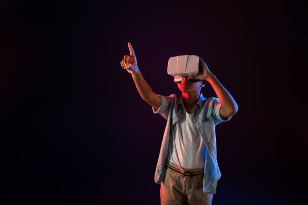 istock Concentrated boy wearing a modern VR headset 981819596
