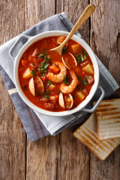 istock Manhattan clam chowder soup close-up. Vertical top view 981819688