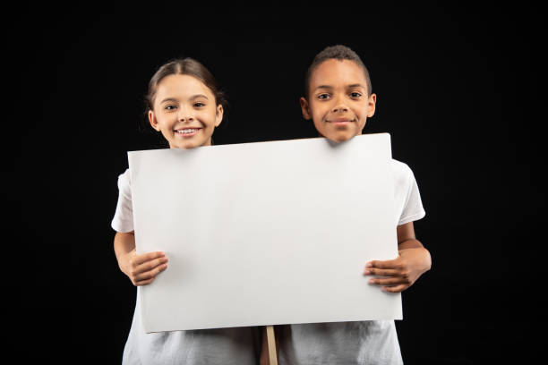 istock Smiling volunteers holding a white table 981823854