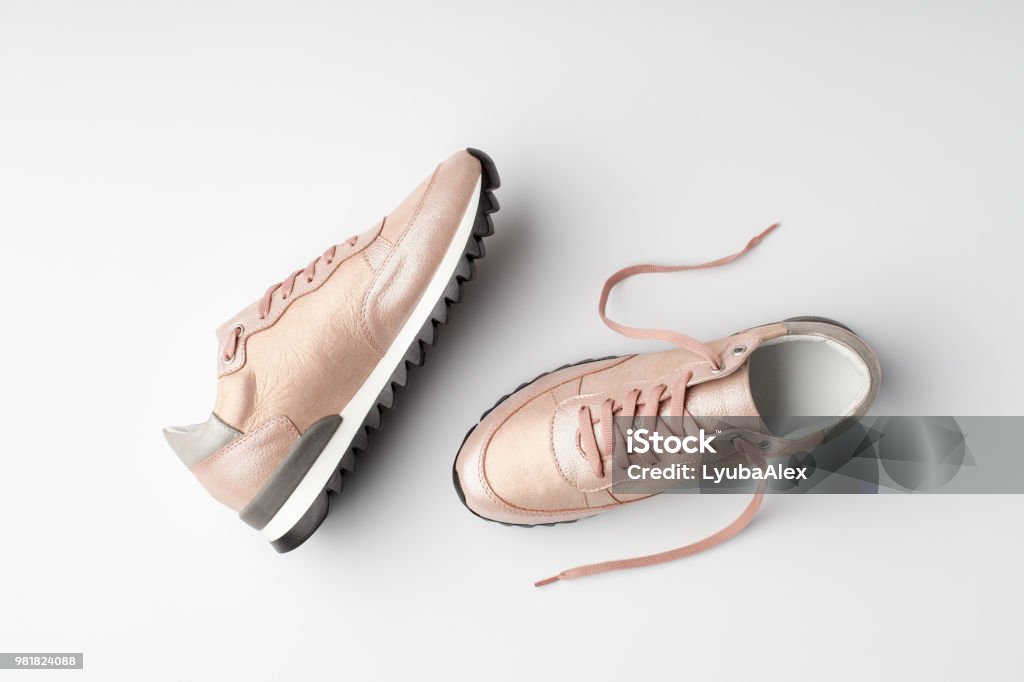 Pastel pink female sneakers on white background. Pastel pink female sneakers on white background. Flat lay, top view minimal background. Shoe Stock Photo