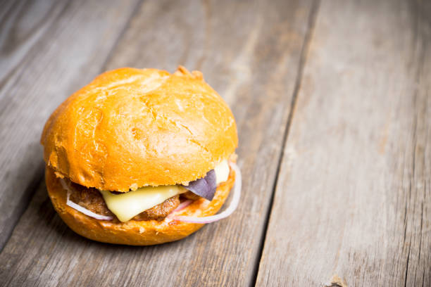 istock Tasty burger with basil on the rustic wooden background 981824370