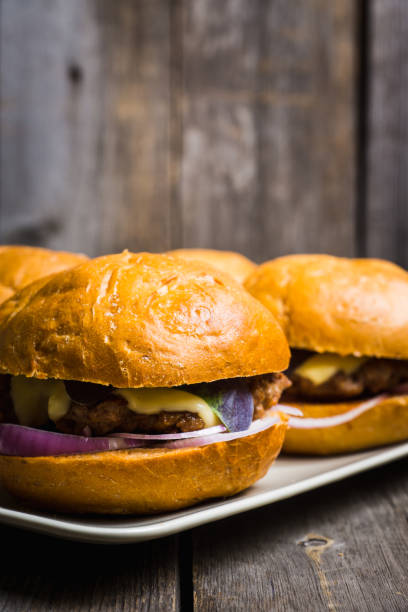 istock Tasty burger with basil on the rustic wooden background 981824388