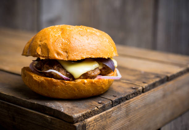 istock Tasty burger with basil on the rustic wooden background 981824484