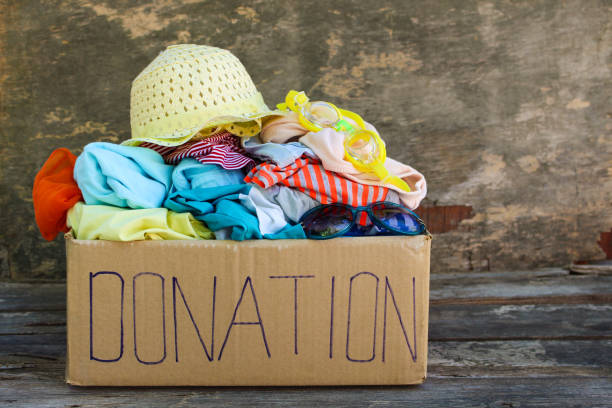 istock Donation box with summer clothes on the old wooden background. 981831962