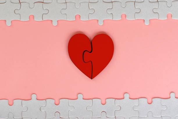 istock two piece red jigsaw love heart with white puzzle on pink background 981836478