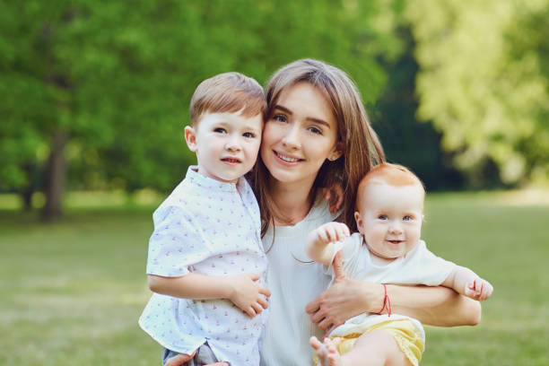 istock Mother with children in summer park 981836674