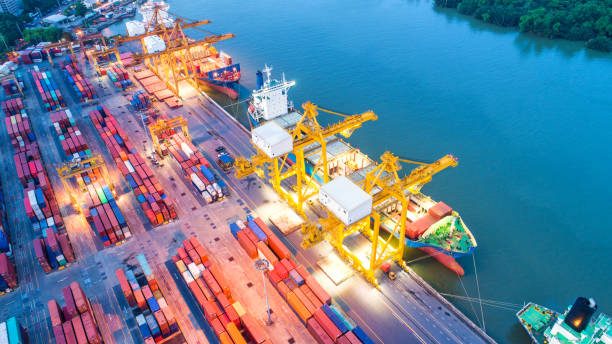 istock Container ship in export and import business and logistics. Shipping cargo to harbor by crane. Water transport International. Aerial view and top view. 981842344