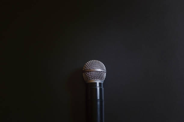 istock Microphone on the book with black background. Call center service operator empty working place. 981842808