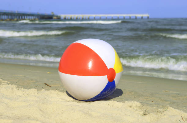 istock Colorful beach ball on sand and waving sea. 981844842