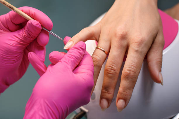 istock beautician applying Polish nails 981850912