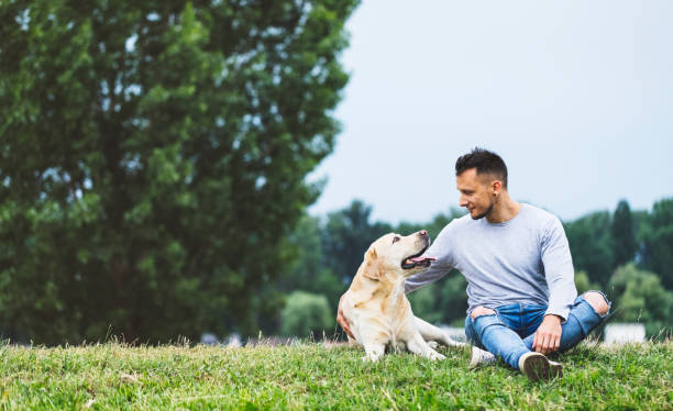 istock Young man hugging his dog in nature 981854202