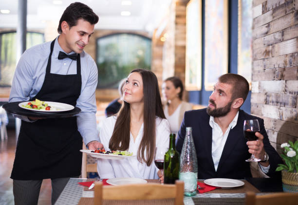 istock waiter man serving company at restaurant 981863582