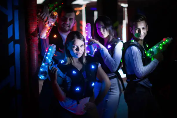 Photo of Young people with laser guns on lasertag arena