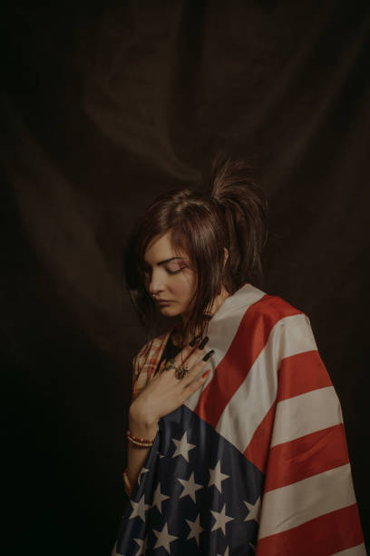 istock Sad girl wrapped in USA flag 981864534