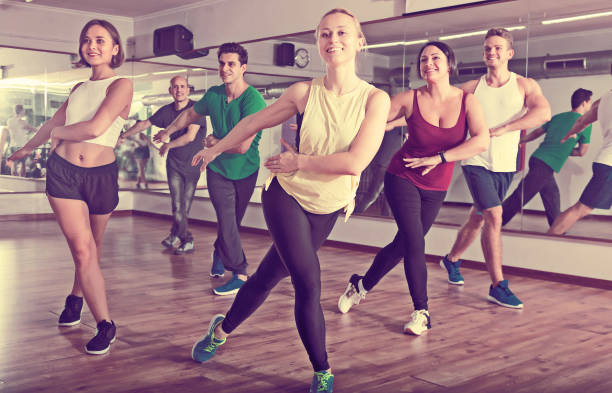 Glad positive people learning zumba steps Glad positive people learning zumba steps in dance hall curtseying stock pictures, royalty-free photos & images