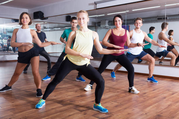 Men and ladies dancing zumba Smiling active men and ladies dancing zumba at lesson curtseying stock pictures, royalty-free photos & images