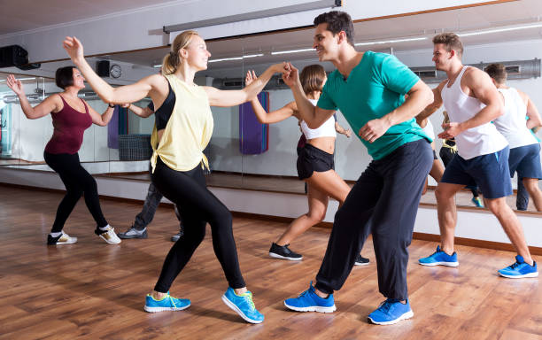 People learning swing at dance class Young smiling men and women dancing swing in dance hall swing dancing stock pictures, royalty-free photos & images