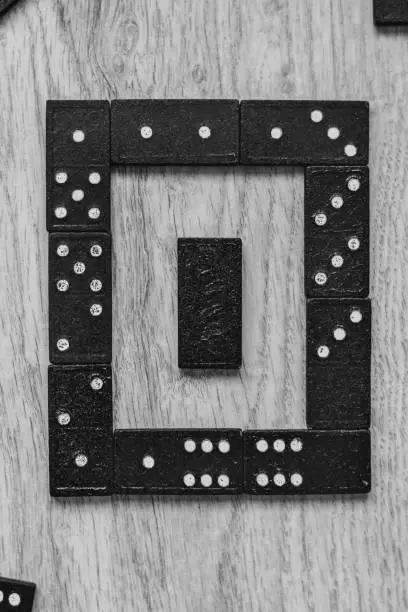 Photo of Developing the game of logic for children and adults. Domino pieces on a wooden background.