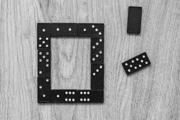 Photo of Developing the game of logic for children and adults. Domino pieces on a wooden background.