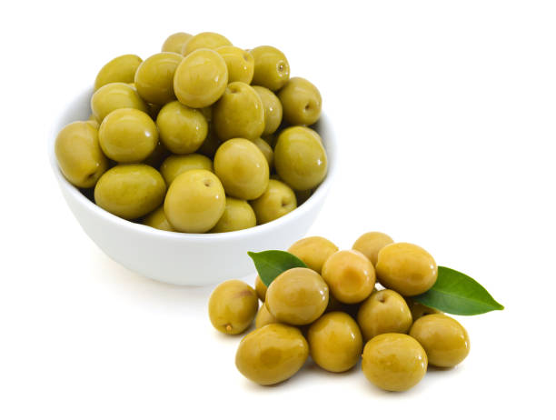 istock pickled green olives in a bowl and olive tree branch on a white background 981883734