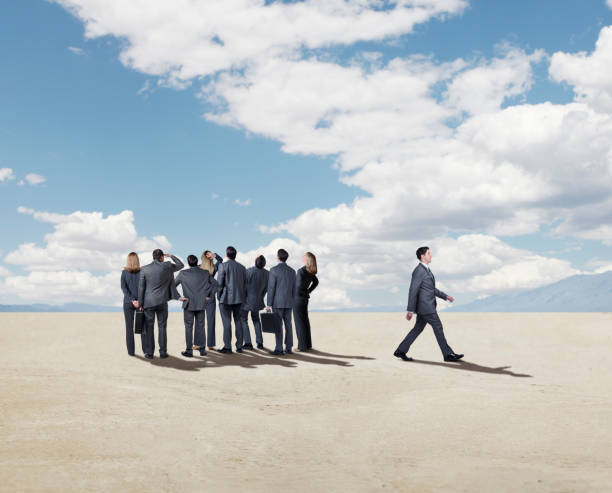 istock Businessman Walks Away From Larger Group 981884398