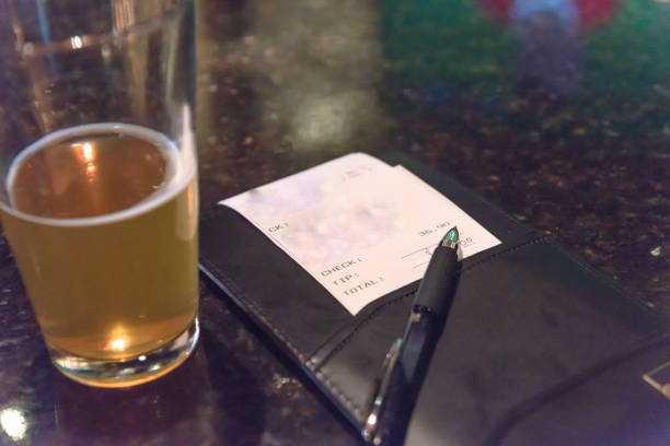 istock Pint glass beer and leather bill holder with restaurant check 981896816