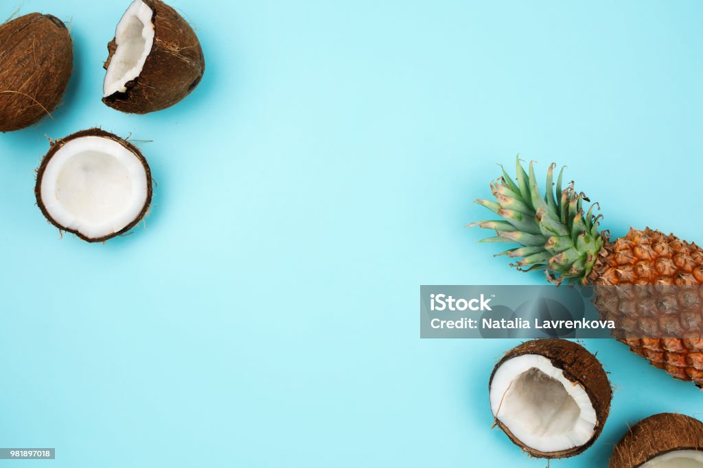 Coconuts and pineapple on blue background with copyspace Pineapple Stock Photo