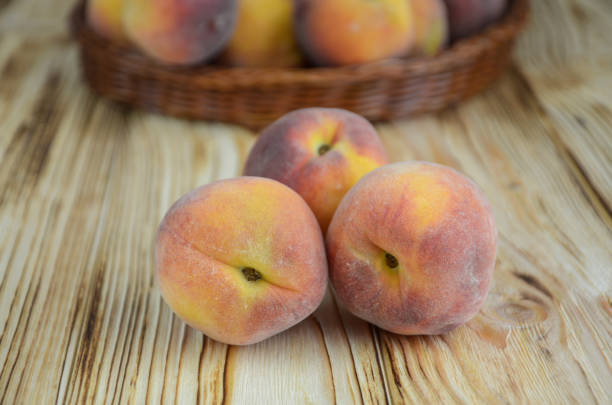 istock Three ripe peaches on a wooden background 981920968