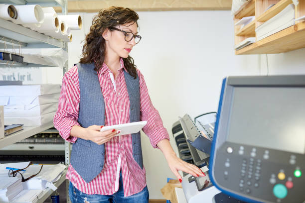 istock Woman calibrating printer in office 981930438