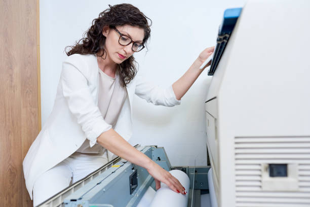 istock Woman putting paper into printer 981930482