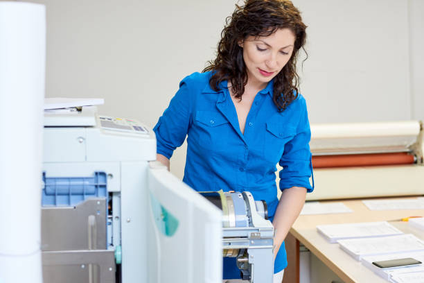 istock Beautiful woman checking printer mechanism 981930546