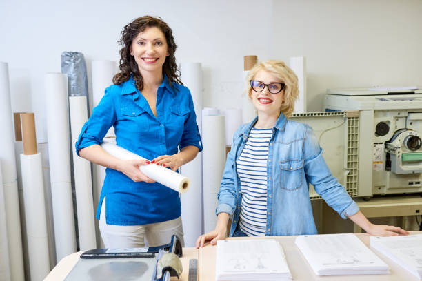 istock Cheerful women in printing office 981930600