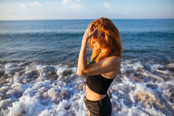 istock Redhead woman standing on the beach 981937362