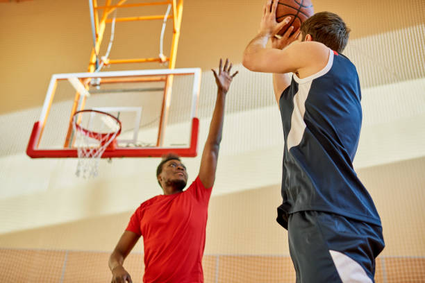 istock Two men playing basketball in gym 981937792