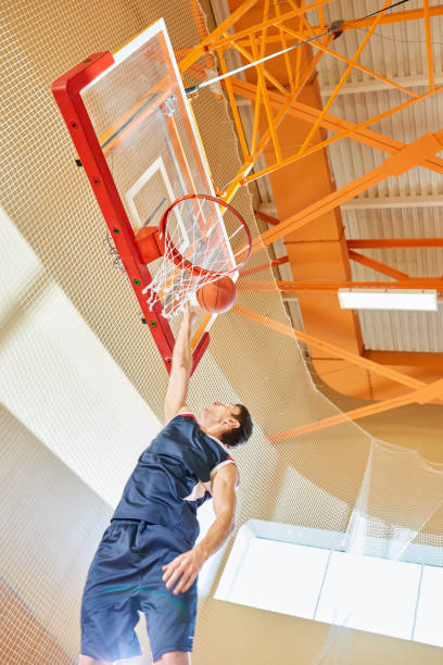 istock From below man shooting ball into basket 981937822